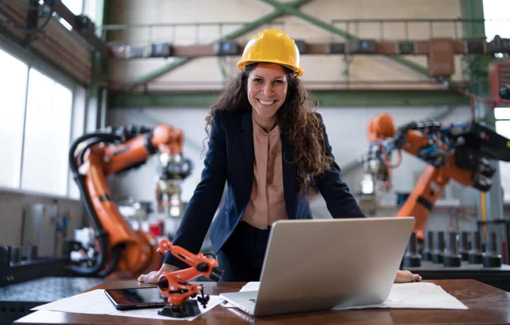A portrait of female chief engineer in modern industrial factory using computer.