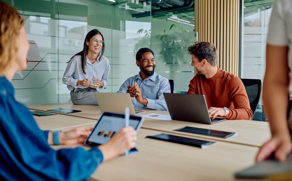 Diverse business team collaborating and laughing during office meeting