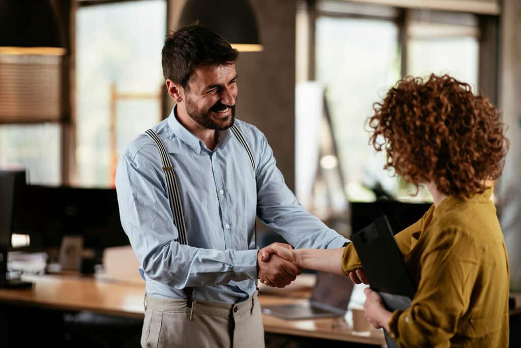 Colleagues in office. Businesswoman and businessman handshake in office..